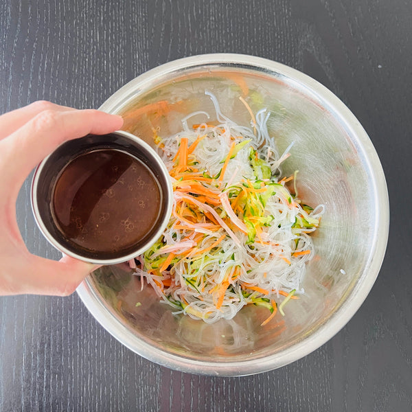 pouring the seasonings into the salad